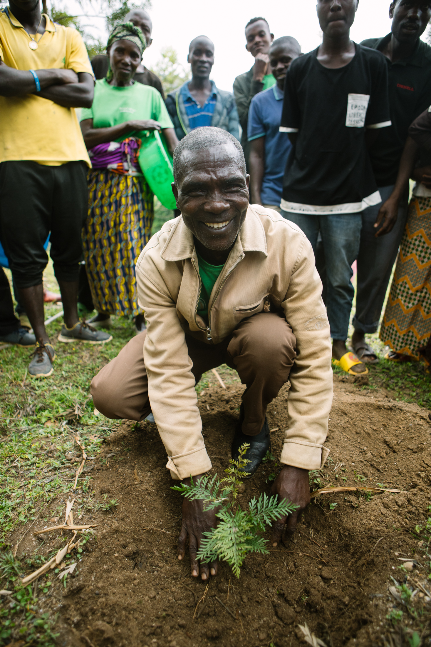 Man looking at the camera as he plants a tree